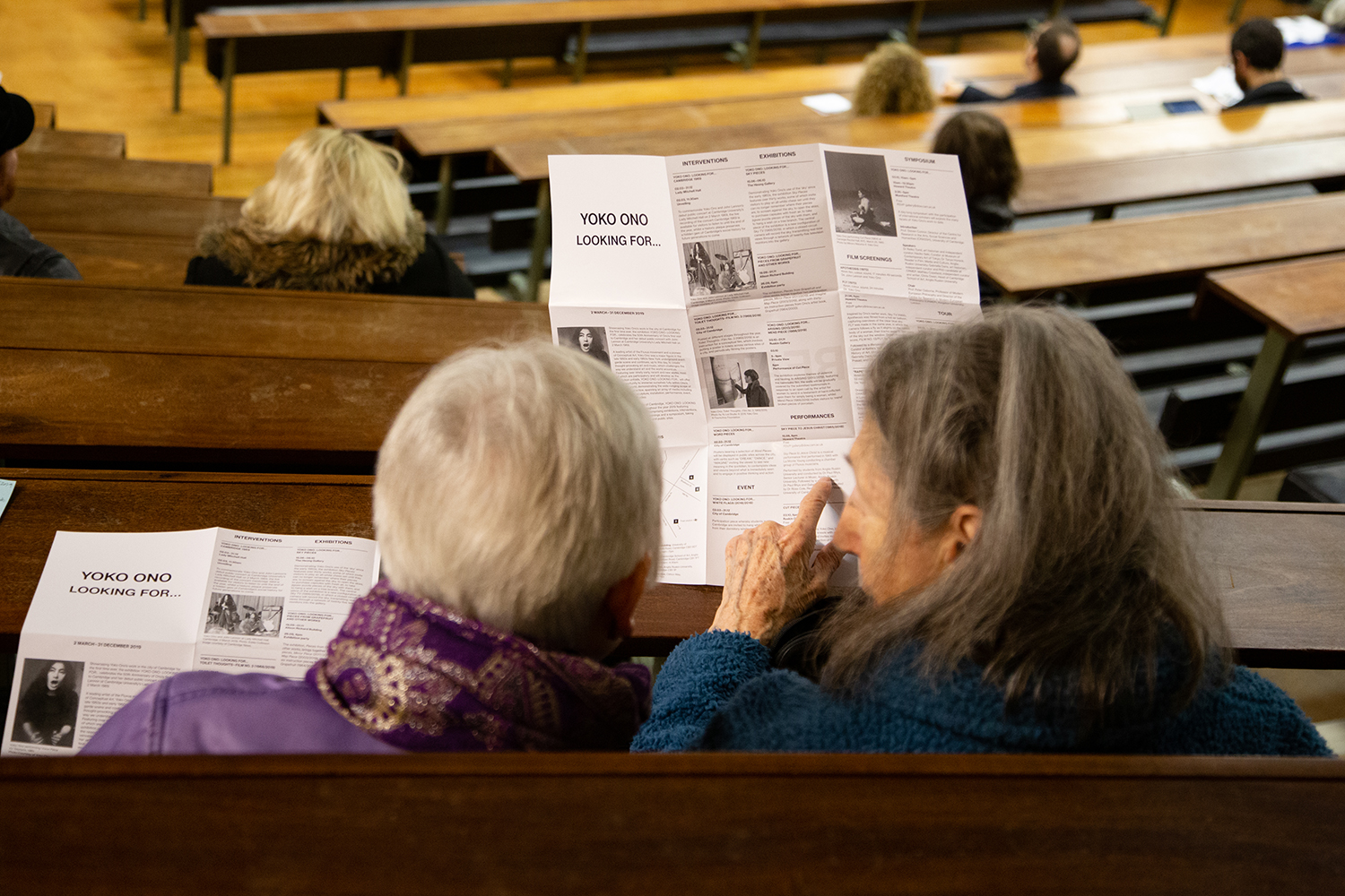 Audience members studying the exhibitions programme